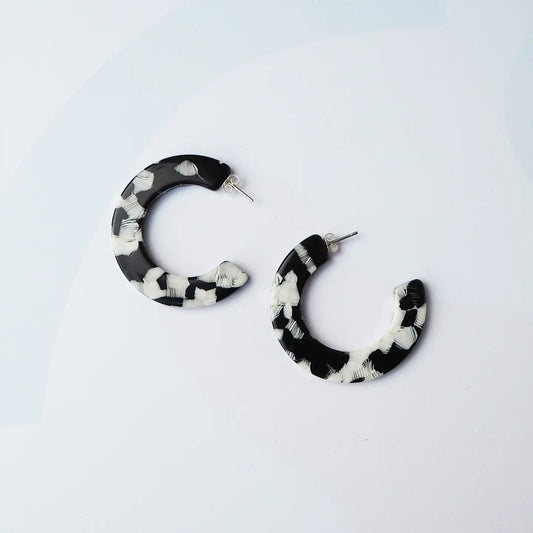 Black and white hoop earrings on a light grey background