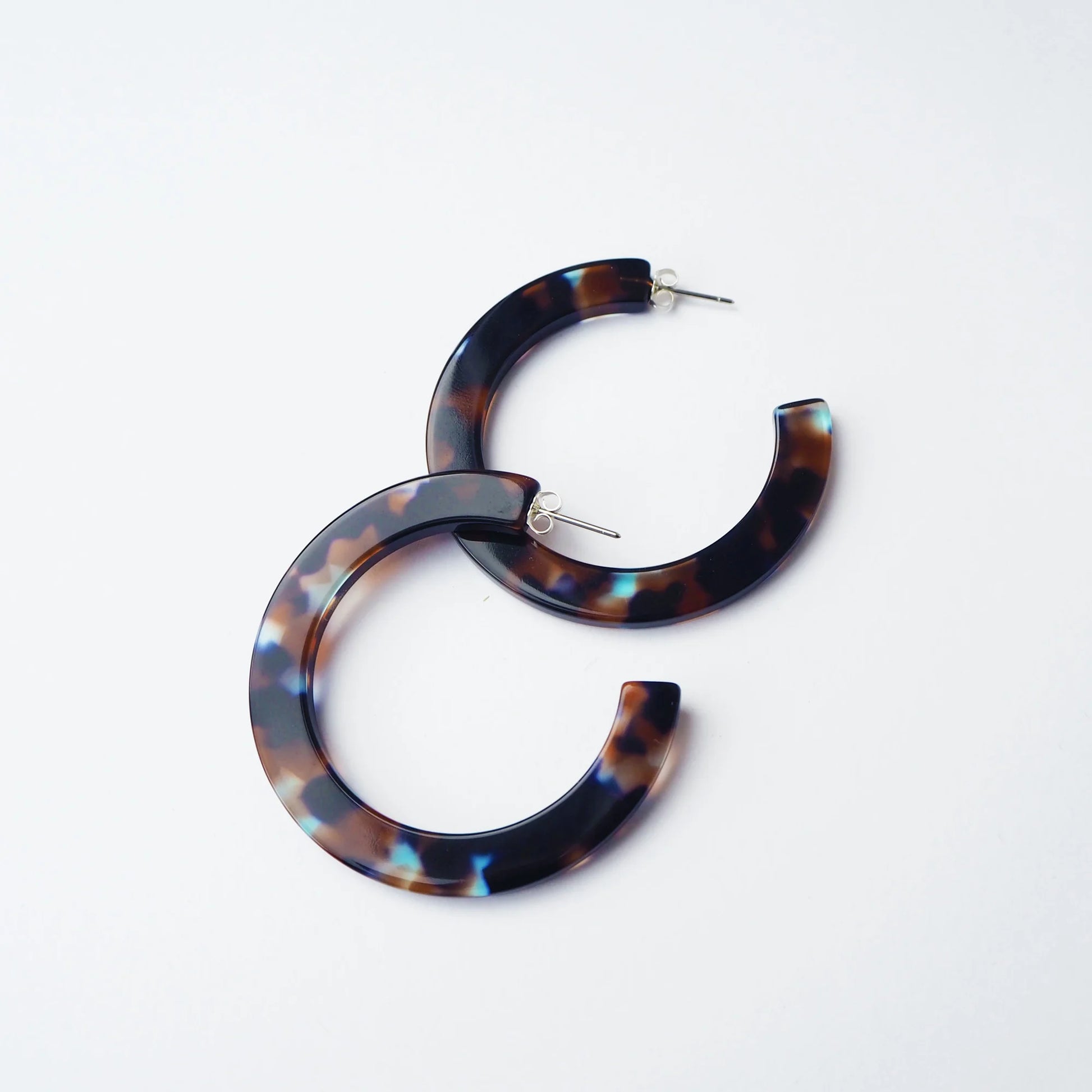 Tortoiseshell hoop earrings on a light grey background
