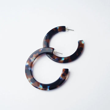 Tortoiseshell hoop earrings on a light grey background