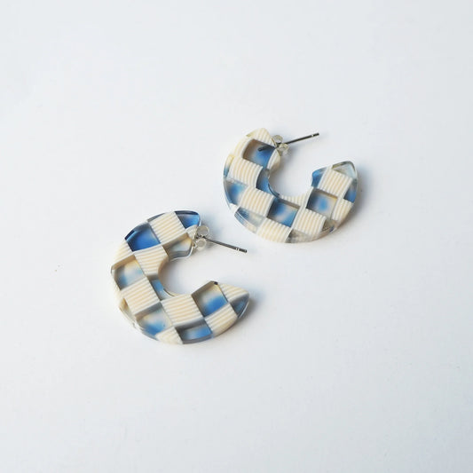 Cream and blue checked round hoop earrings on a white background