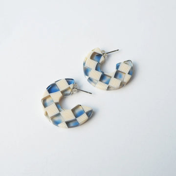 Cream and blue checked round hoop earrings on a white background