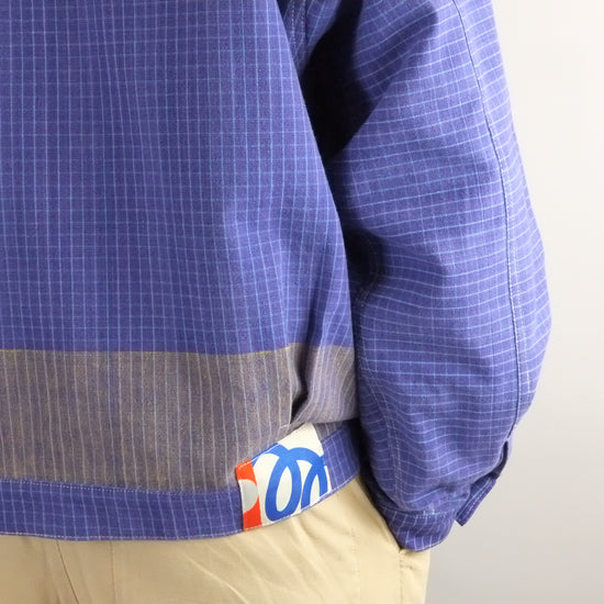 Blue checkered shirt with a visible brand logo on a plain background