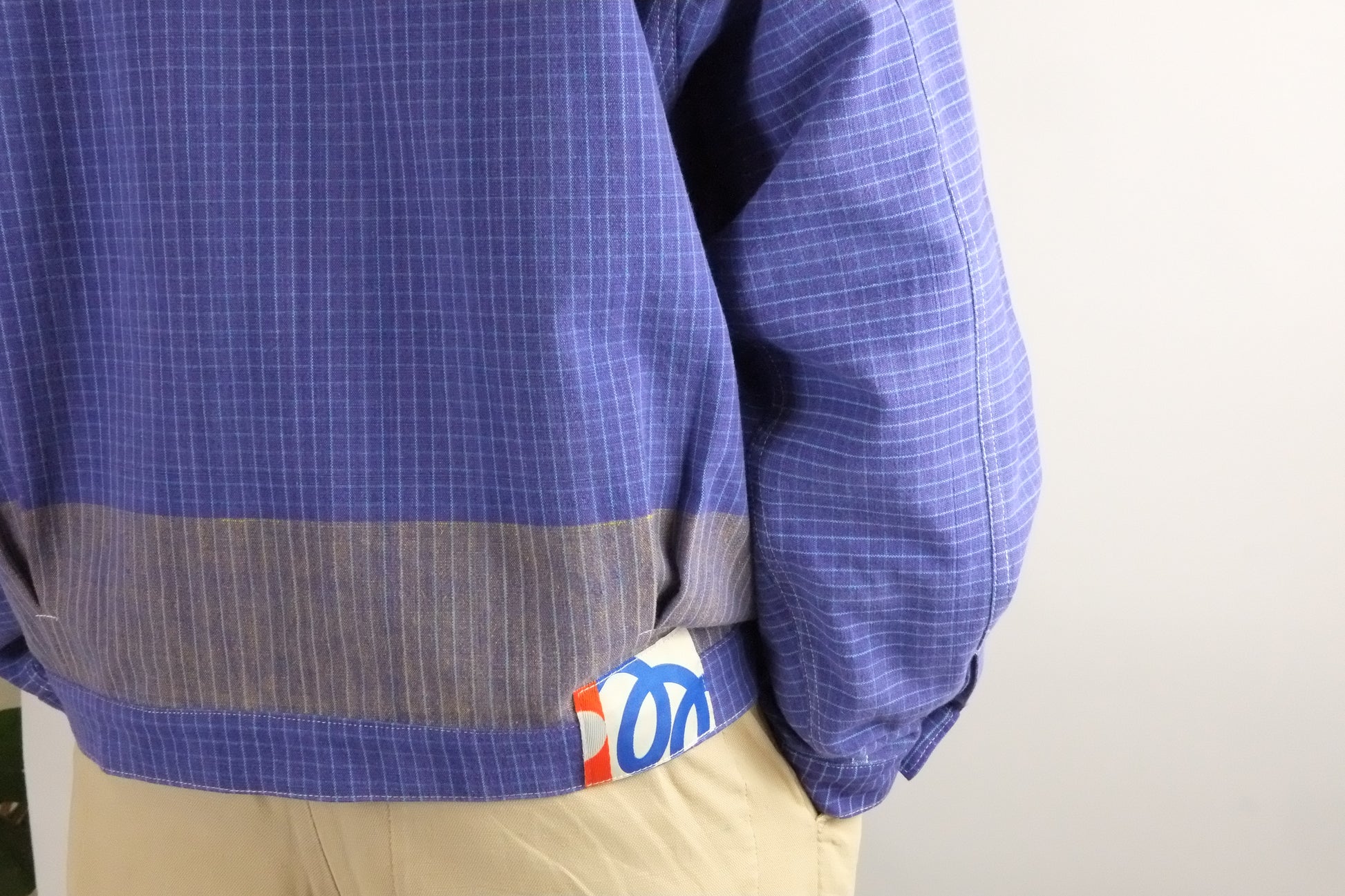 Blue checkered shirt with a visible brand logo on a plain background