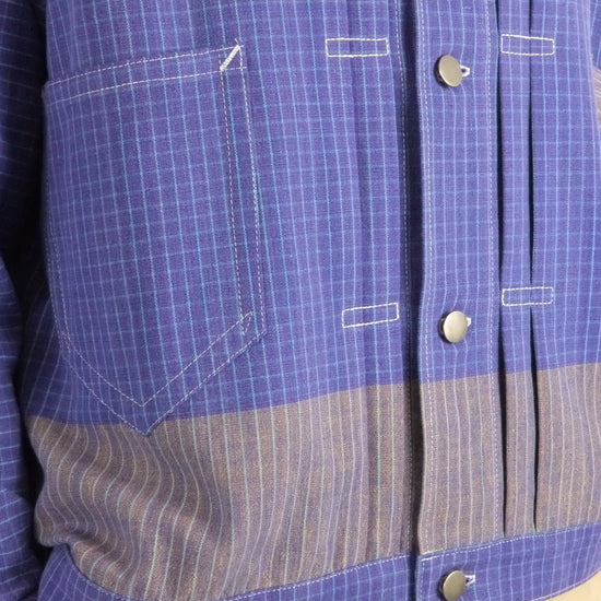 Close-up of a blue checkered shirt with a focus on the chest pocket and buttons.