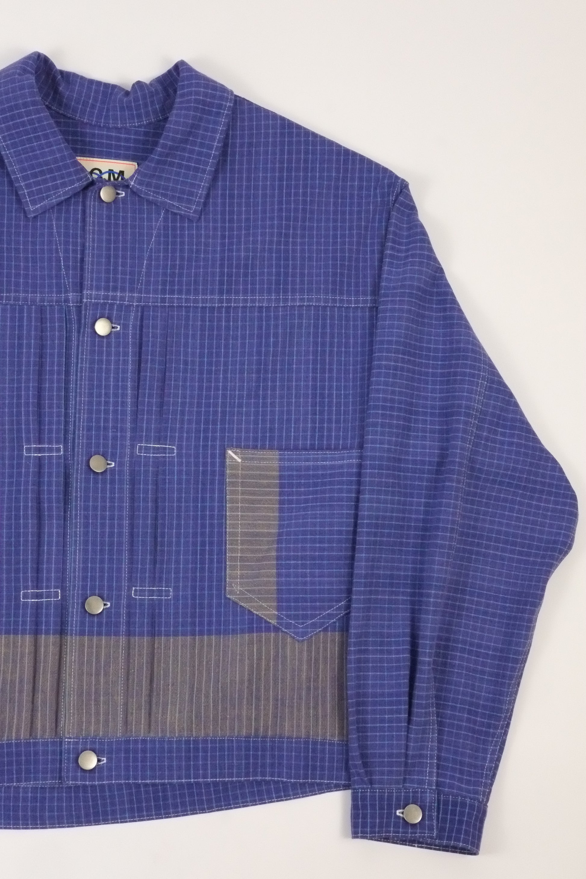 Blue checkered shirt with a gray stripe on a white background