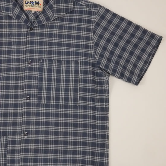 Blue and white plaid shirt with a brand label on a light gray background