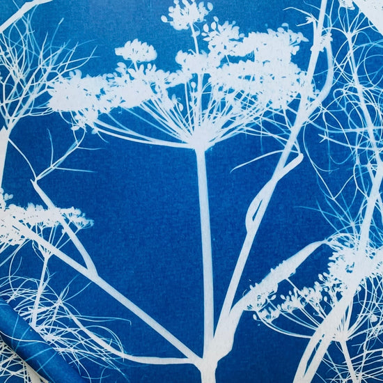 White floral and branch pattern on a blue textured background