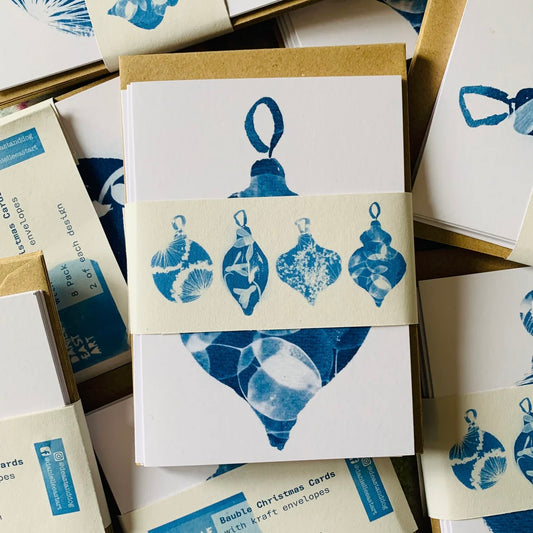 Stack of Christmas cards with blue bauble ornament design on a white background