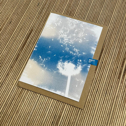 a blue and white faded image of dandelions 