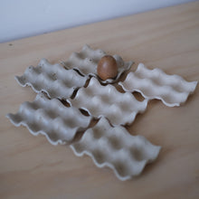Load image into Gallery viewer, White ceramic egg crate with a single brown egg on a light wooden surface.
