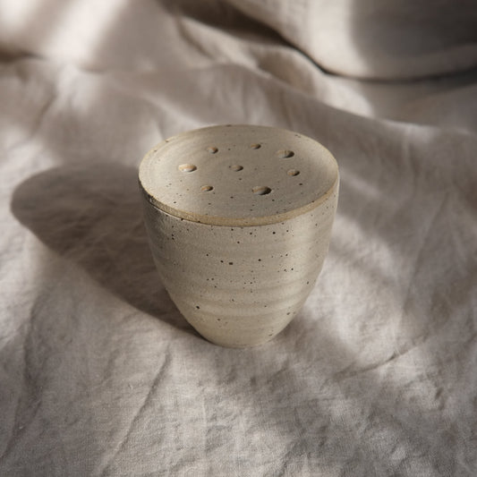 Ceramic pot on a textured fabric surface