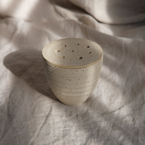 Ceramic pot on a textured fabric surface