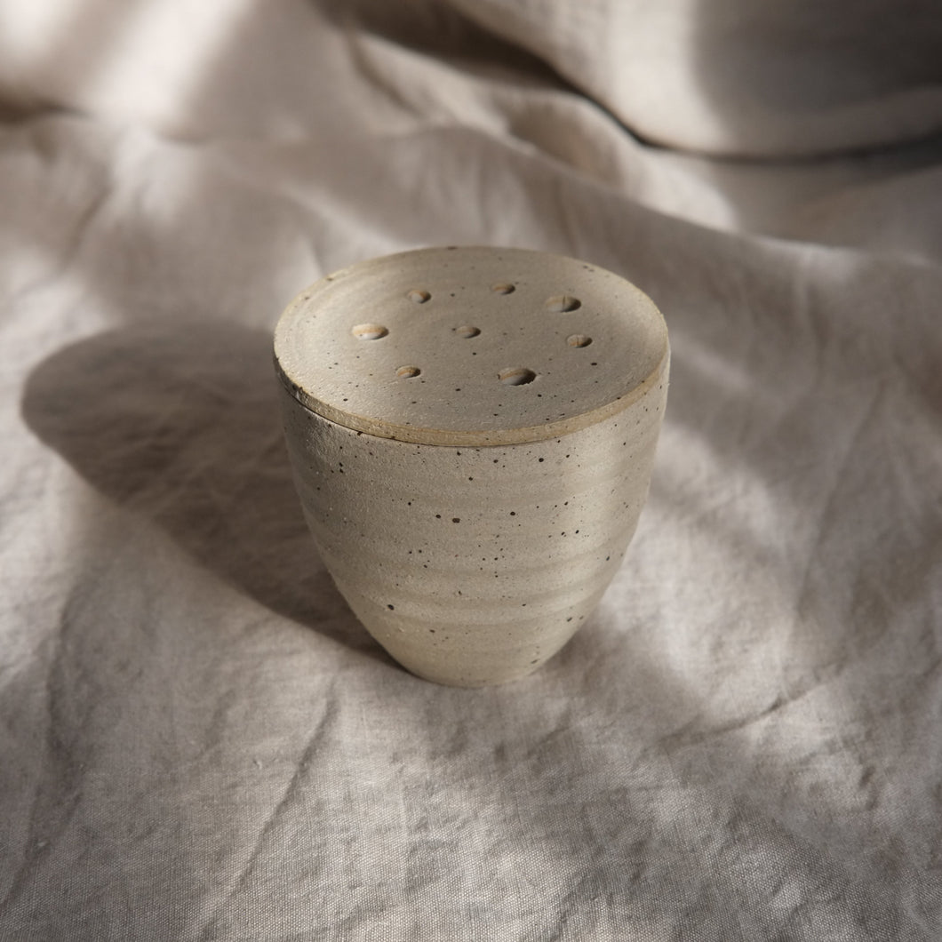Ceramic pot on a textured fabric surface