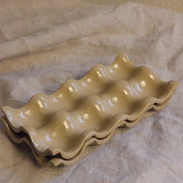 Beige ceramic egg-shaped cookie mold on brown paper