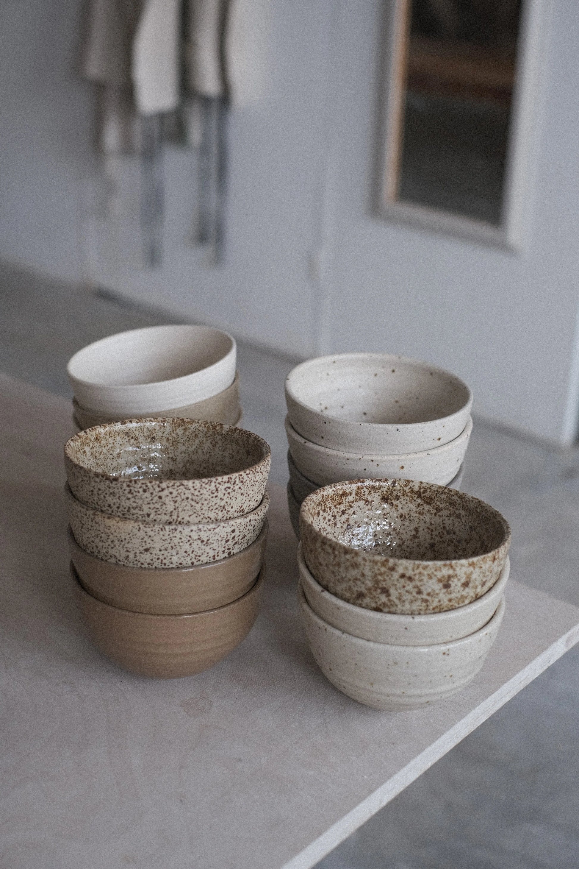 Set of ceramic bowls in various colors on a light surface.