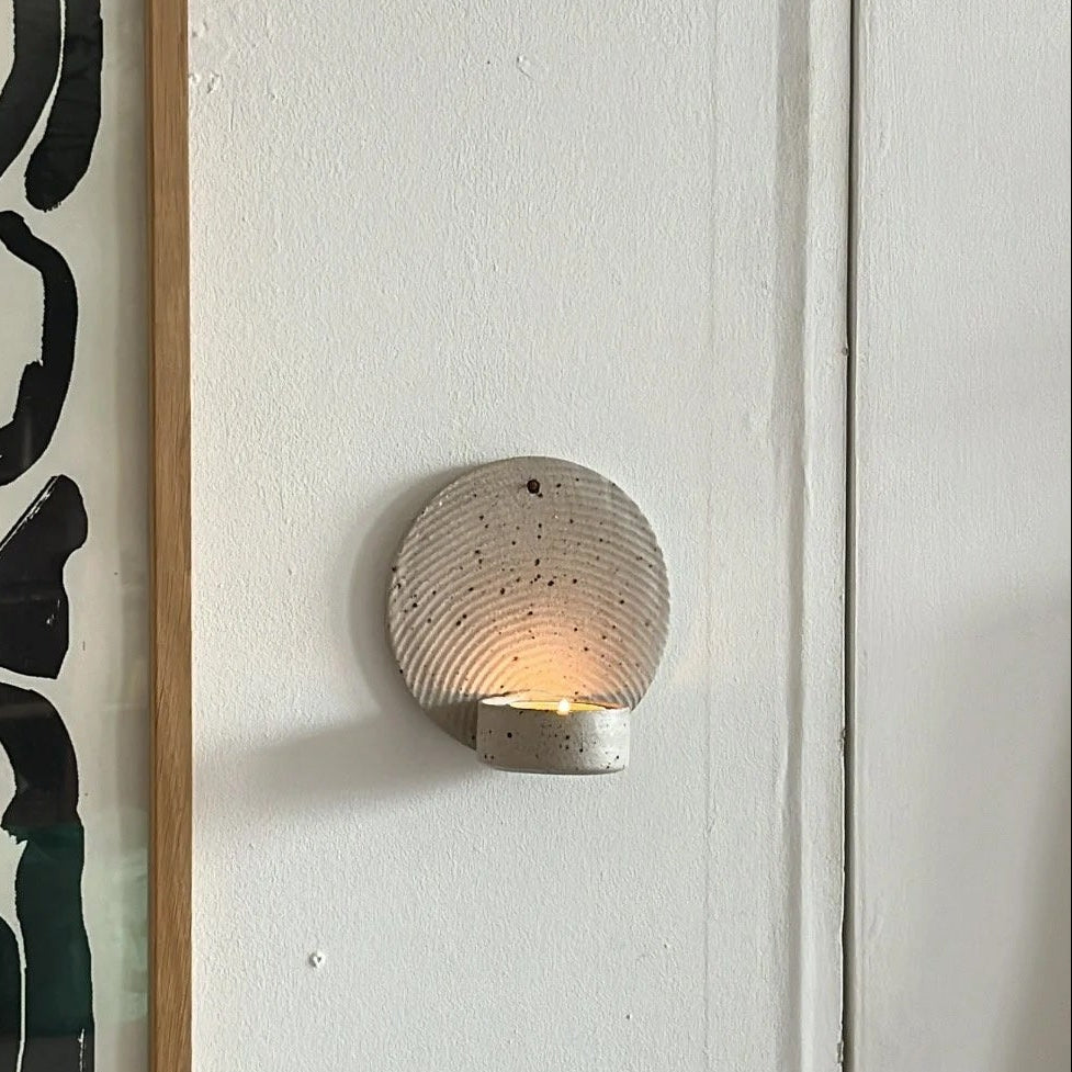 Wall sconce with abstract art on a white wall