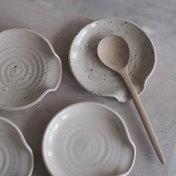 Set of ceramic bowls with a wooden spoon on a gray surface