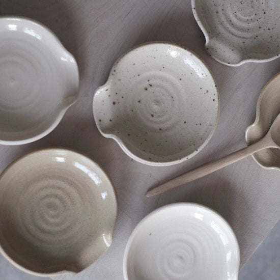 Set of ceramic bowls and a ladle on a gray surface