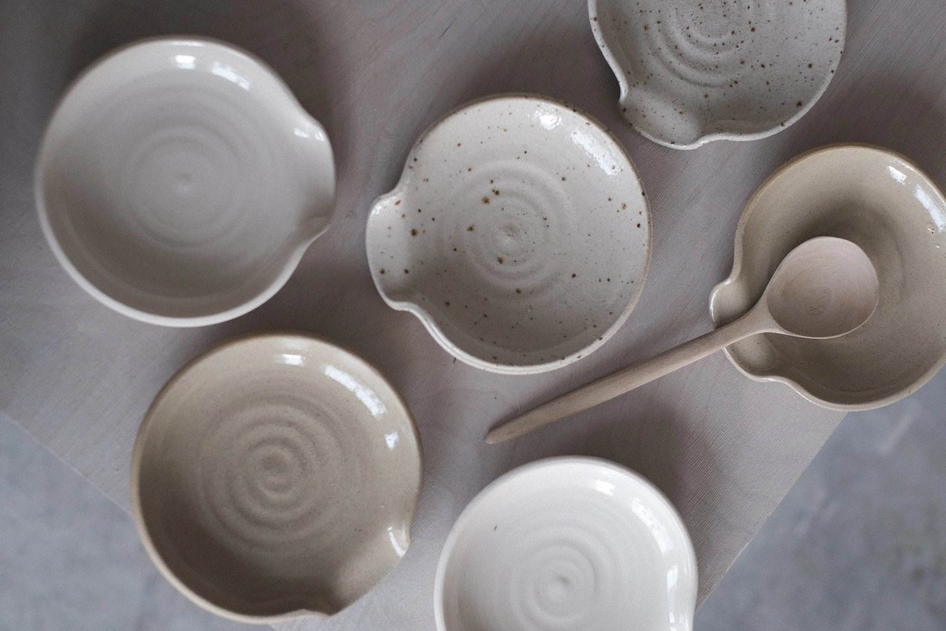 Set of ceramic bowls and a ladle on a gray surface
