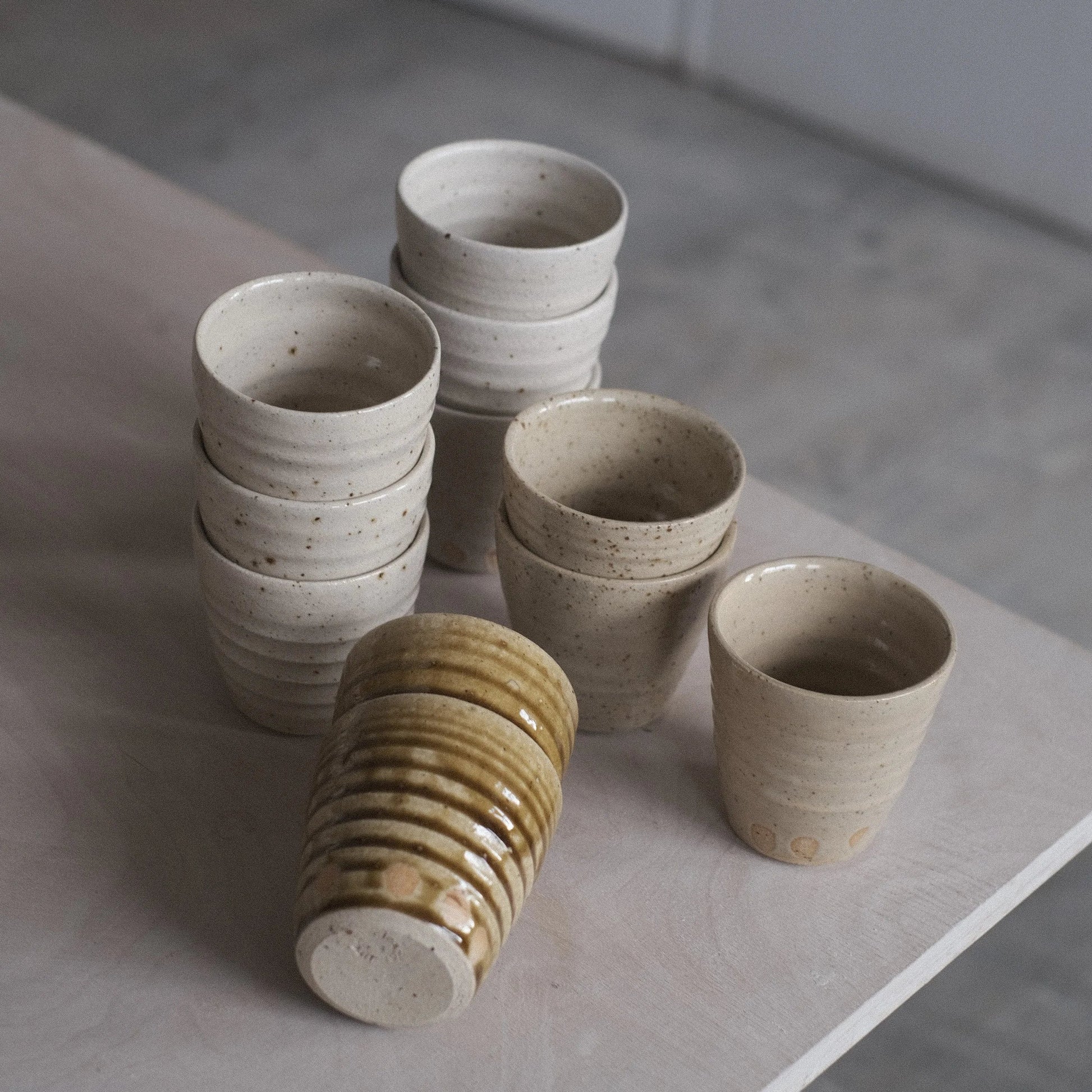 Collection of ceramic cups on a gray surface with a neutral background
