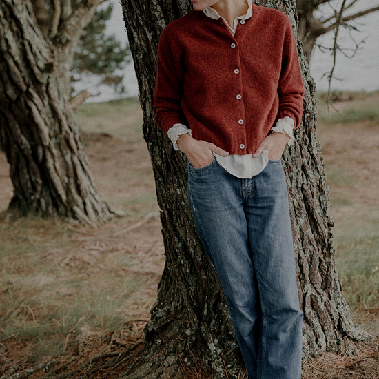 Woman leaning against a tree in a natural setting