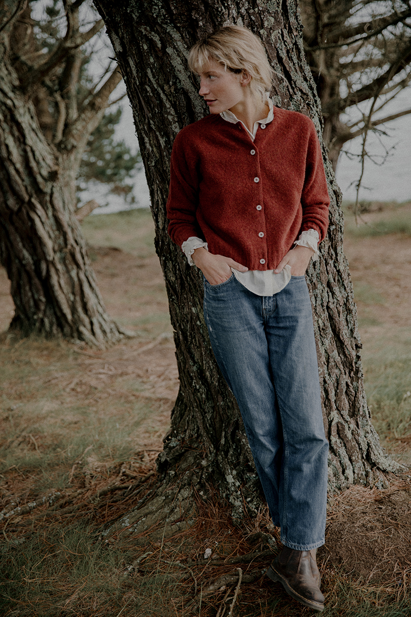 Woman leaning against a tree in a natural setting