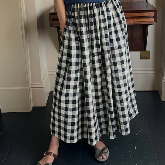 Person wearing a black and white checkered skirt indoors.