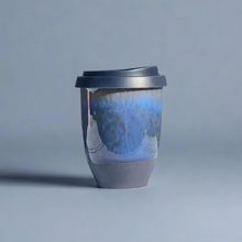 Load image into Gallery viewer, An 8oz stoneware travel cup with a silicone lid, featuring a dark colorway of blue and black glaze.
