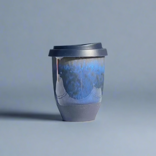 An 8oz stoneware travel cup with a silicone lid, featuring a dark colorway of blue and black glaze.