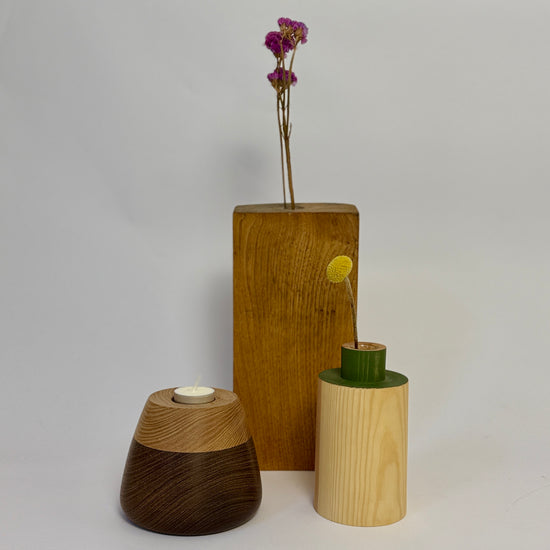 Three wooden vases with different designs on a plain background
