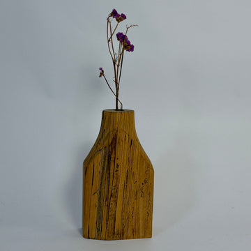 Wooden vase with a plant on a gray background