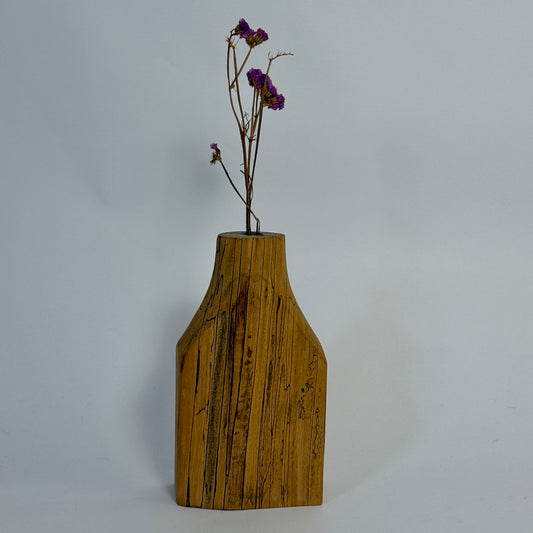 Wooden vase with a plant on a gray background
