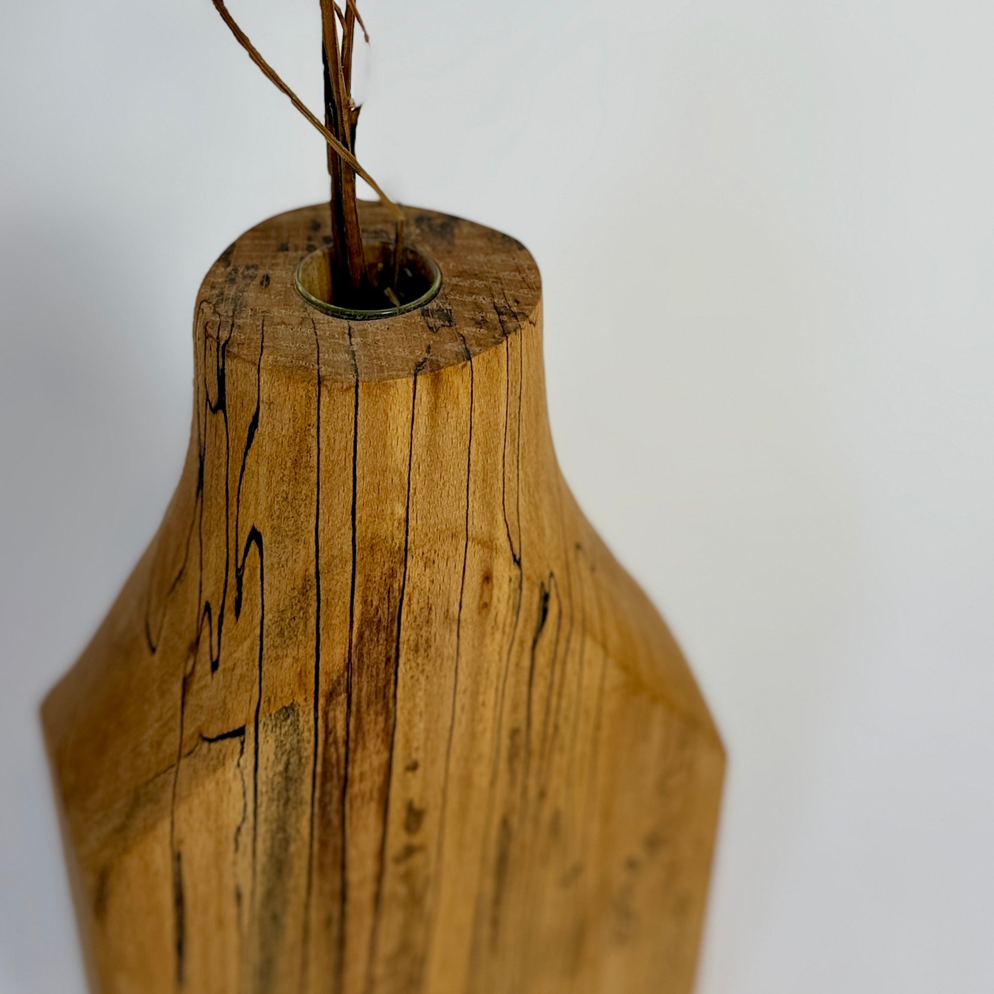 Wooden vase with a textured surface on a white background