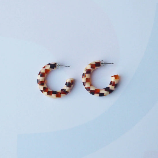 checkered brown and beige acetate hoop earrings with surgical steel posts on a grey background