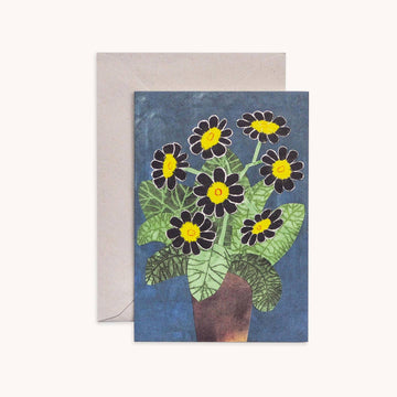 a blue card with dark flowers and leaves on the front