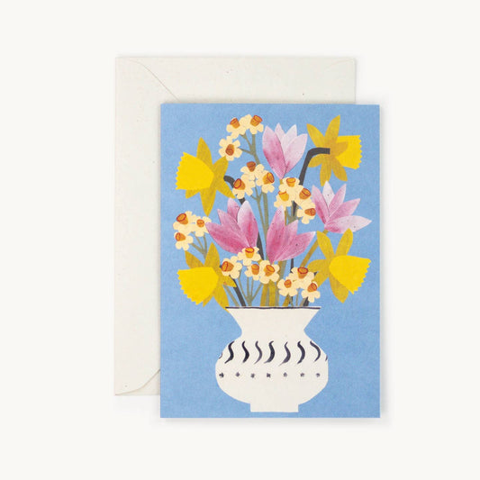 A blue card with a vase of a variety of flowers 