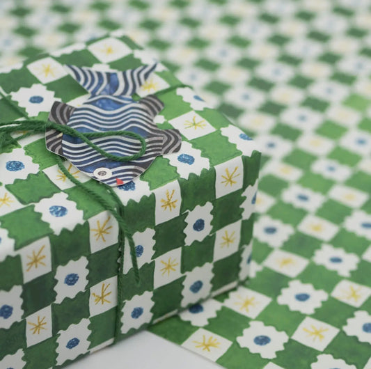 Gift box with decorative paper on a green and white checkered background