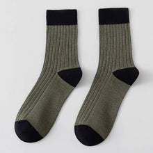 Load image into Gallery viewer, Pair of green socks with black toes and cuffs on a light grey background
