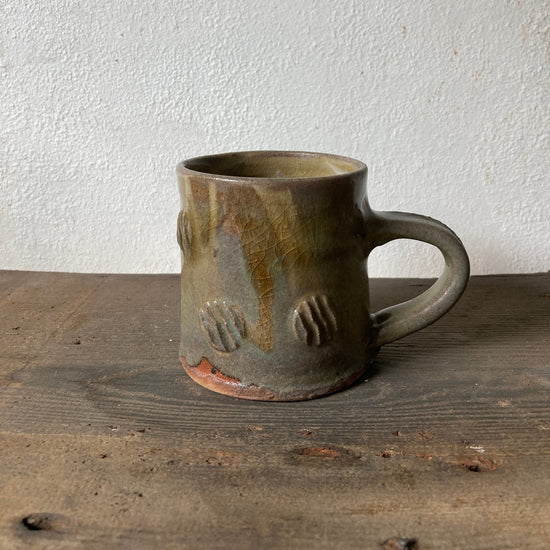 Ceramic mug with textured surface on a wooden surface