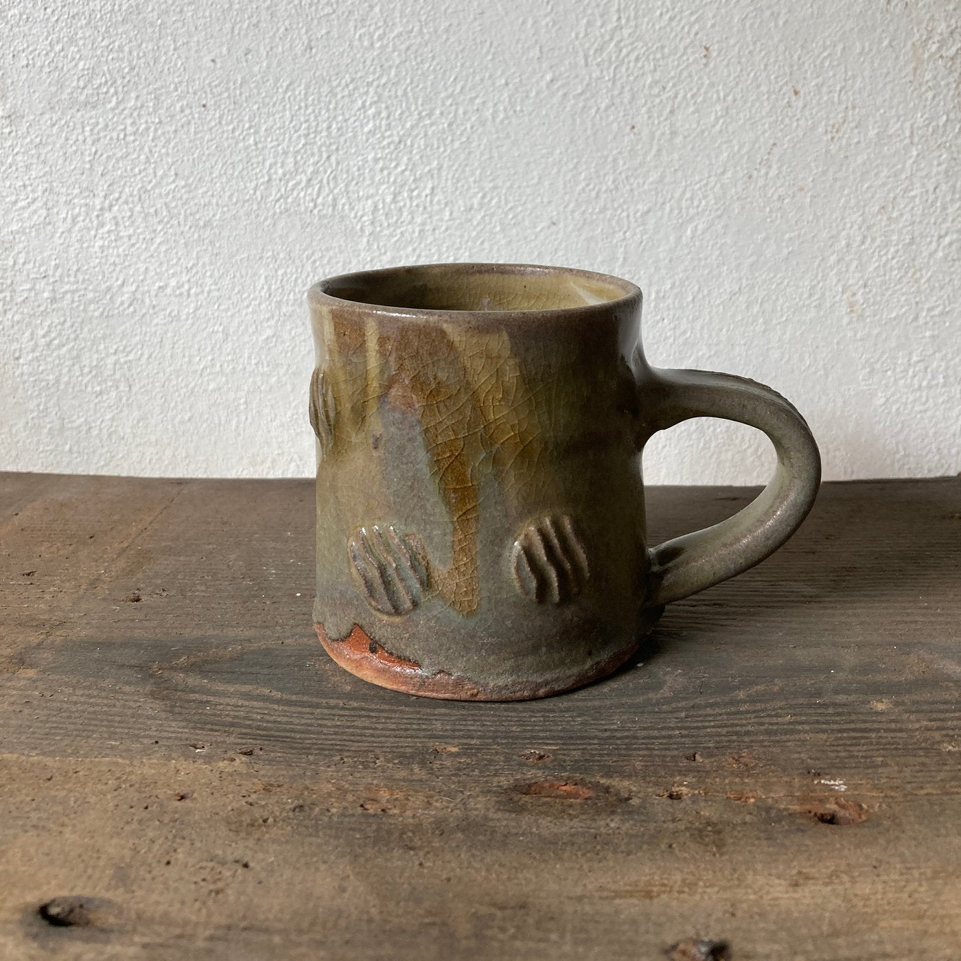Ceramic mug with textured surface on a wooden surface
