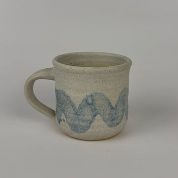 Gray ceramic mug with blue wave design on a gray background