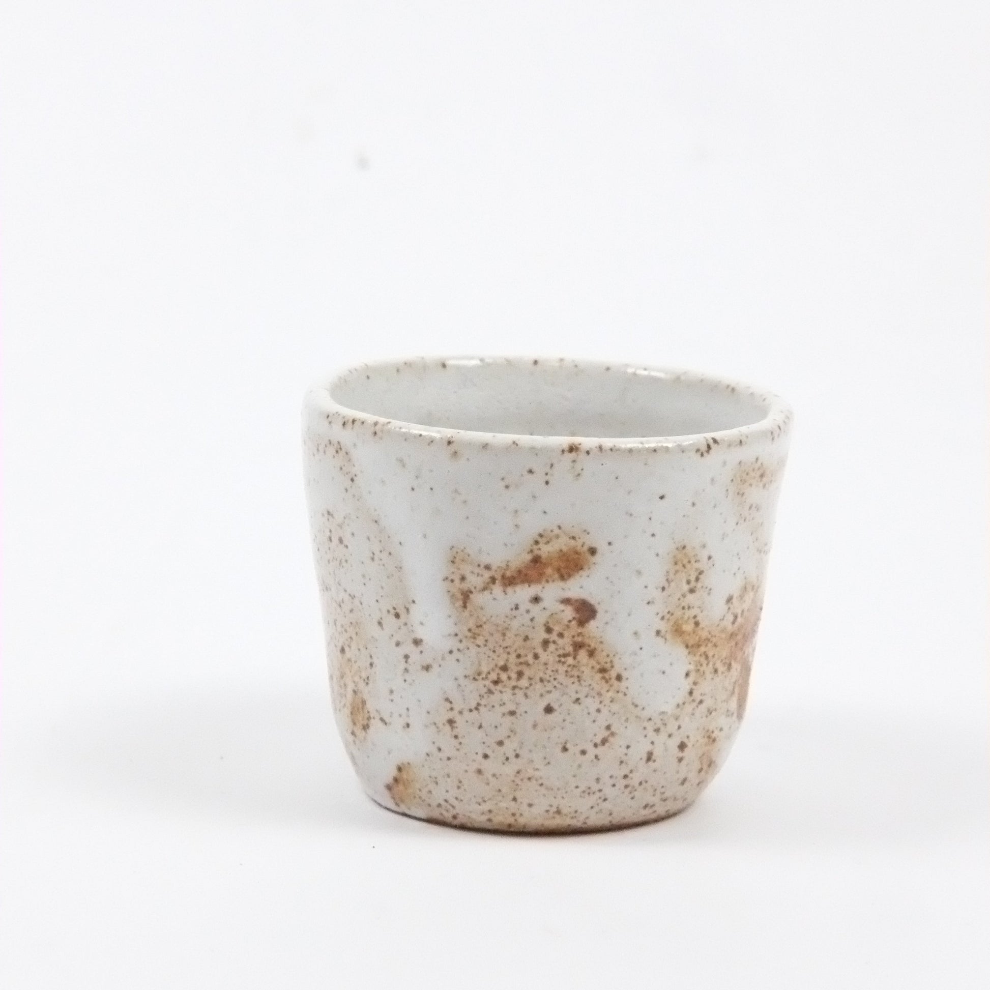 Small ceramic cup with brown speckles on a white background