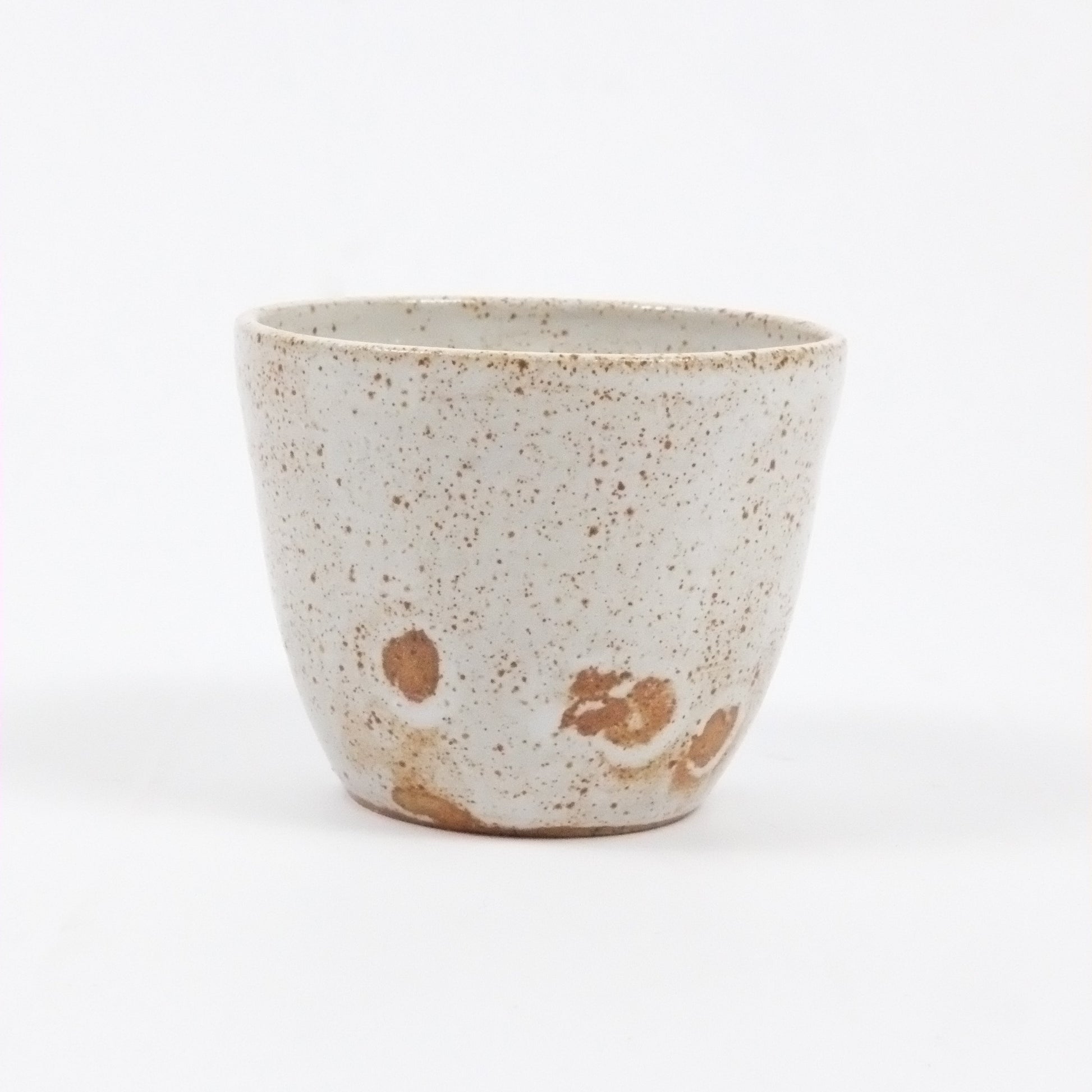 Speckled ceramic cup on a white background