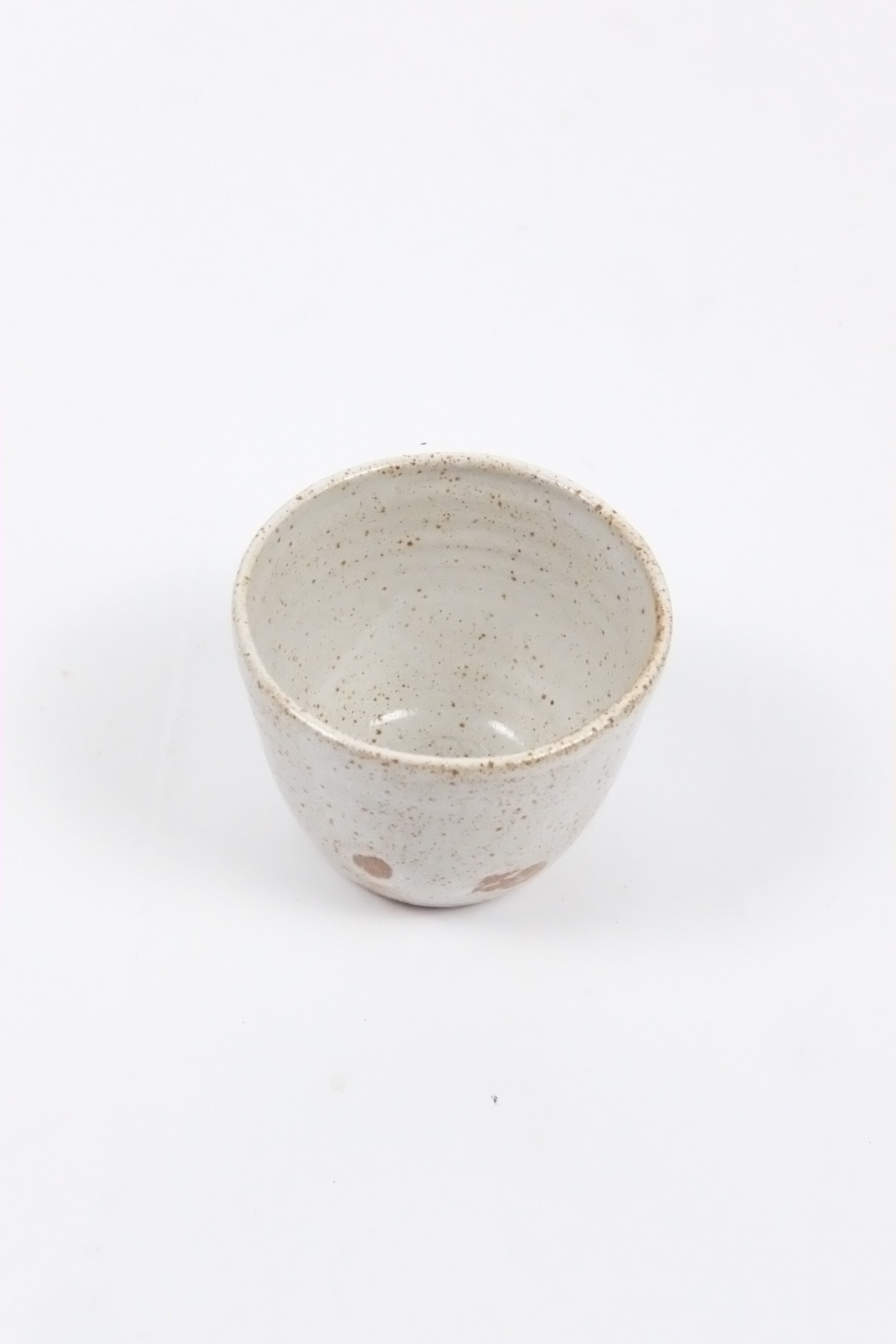 Speckled ceramic cup on a white background