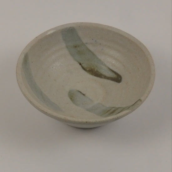 A small striped beige bowl on a white background 