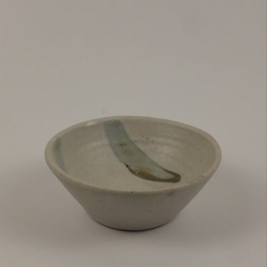 A small ceramic striped bowk on a white background 