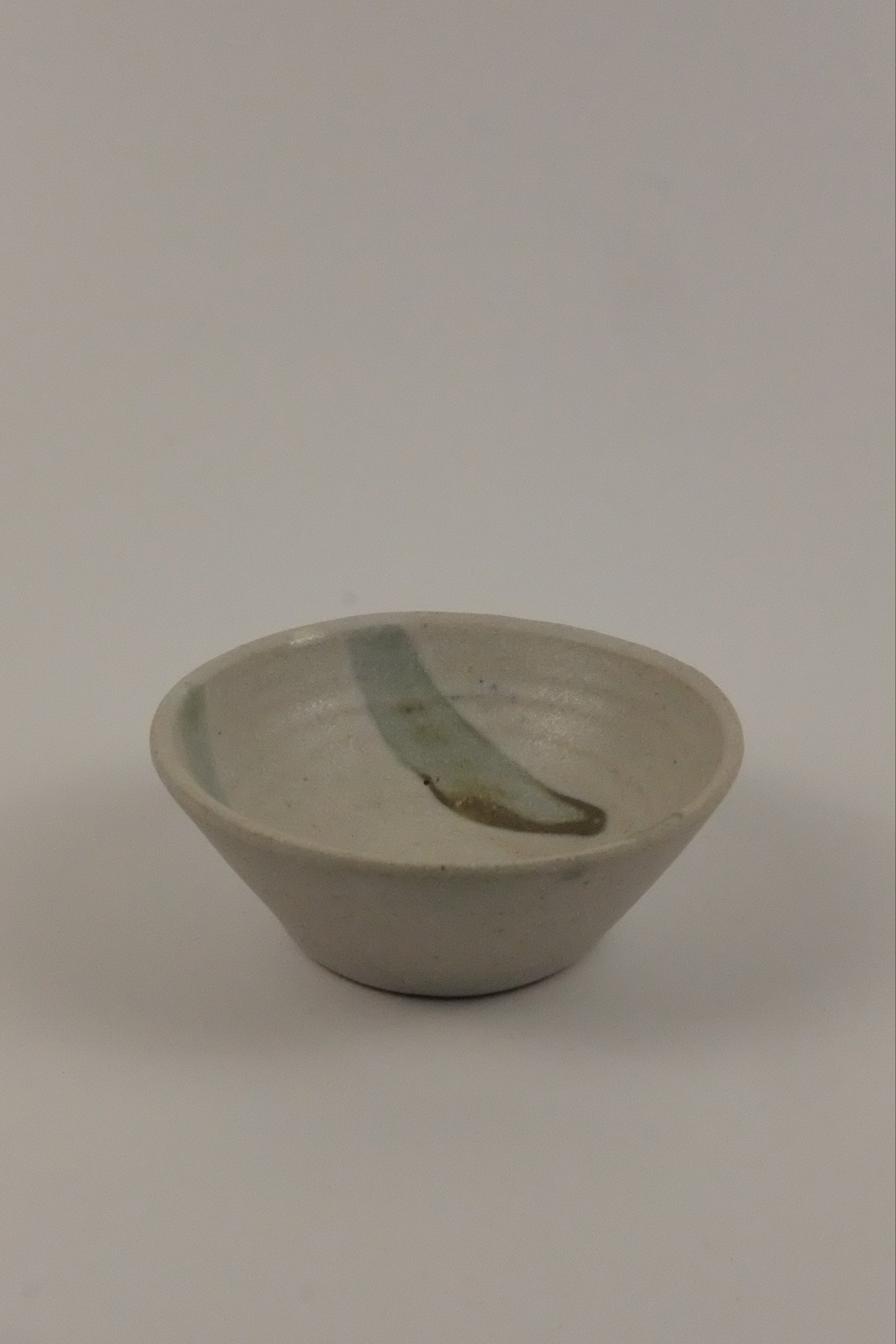 A small ceramic striped bowk on a white background 