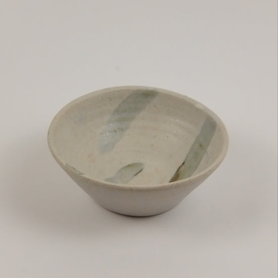 Ceramic bowl with green accents on a white background