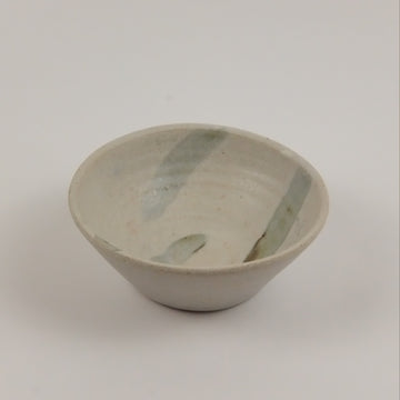 Ceramic bowl with green accents on a white background