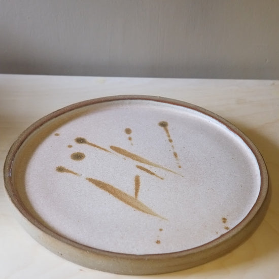 Round ceramic plate with abstract design on a plain background